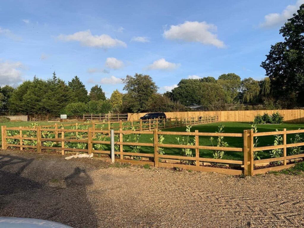 This is a photo of post and rail fencing with a gravel board installed at the base to create a flower bed, and at the rear is feather edge fencing along the edge of the garden. All works carried out by Fast Fix Fencing Red Lodge